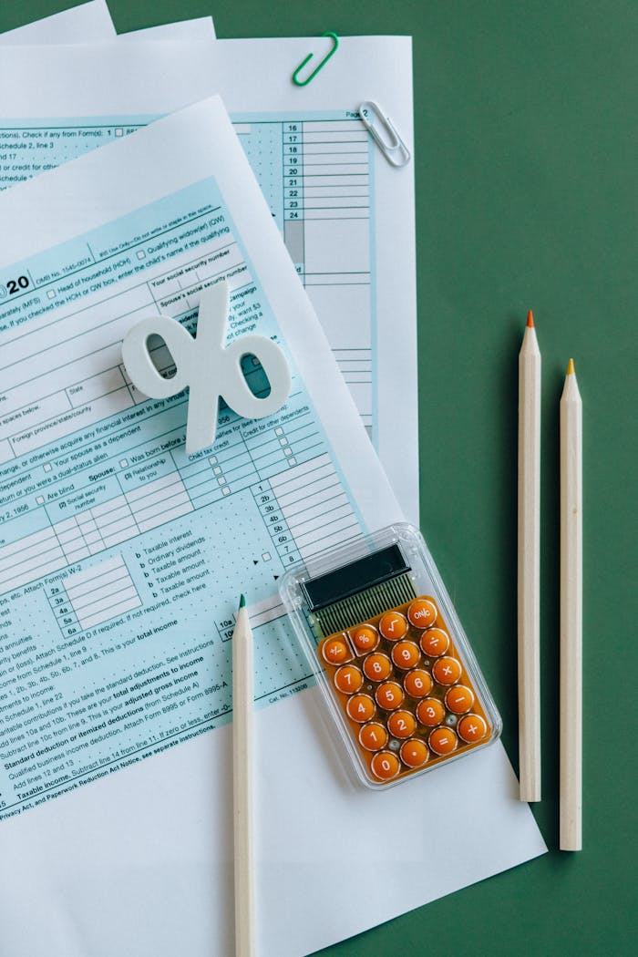 why-choose-us Flat lay of tax documents, calculator, and pencils on green surface.