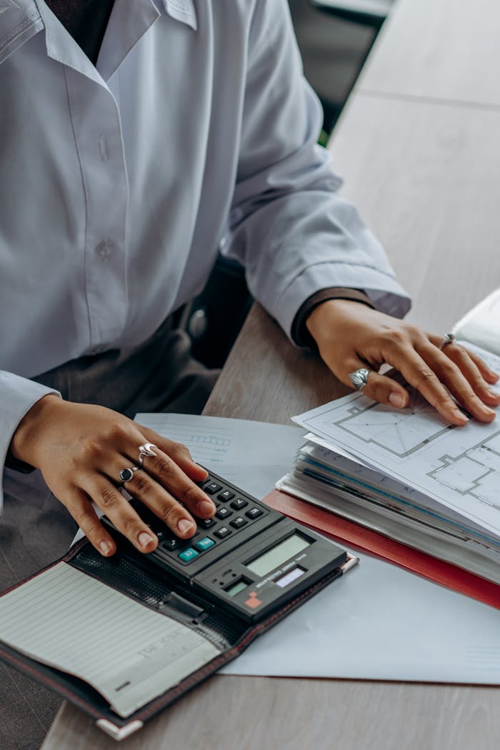 who-we-are Accountant calculates finances with a calculator and documents on a desk.